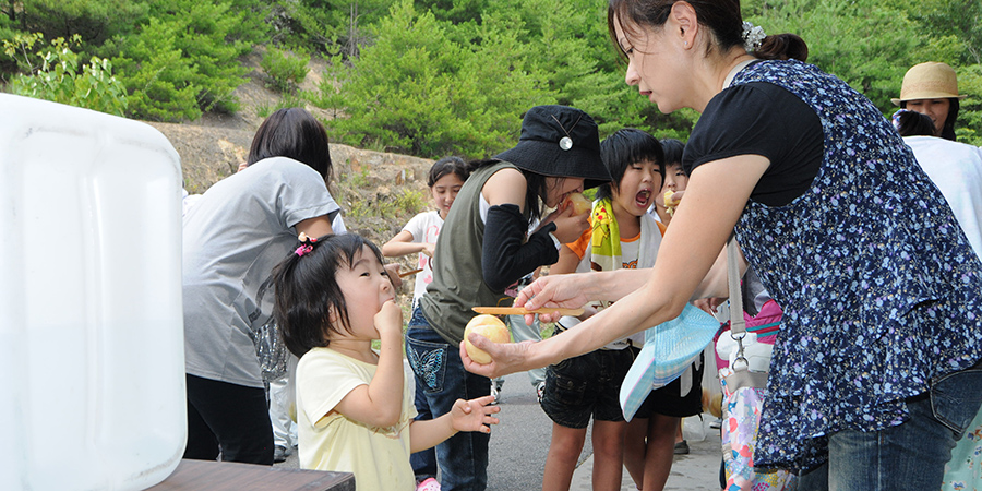 おいしそうに桃を食べる子供の写真
